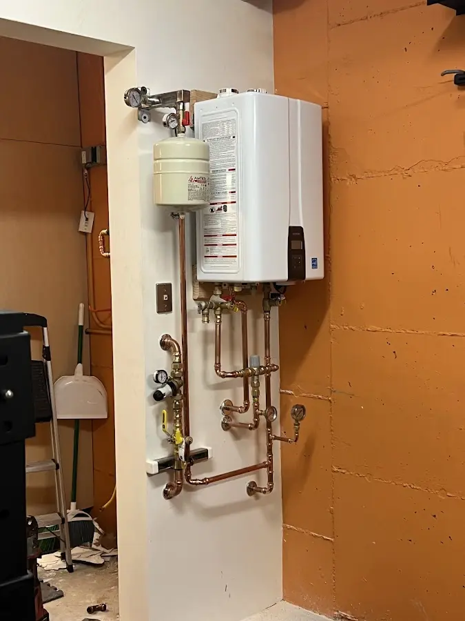Plumbing technician inspecting water heater connections in La Marque